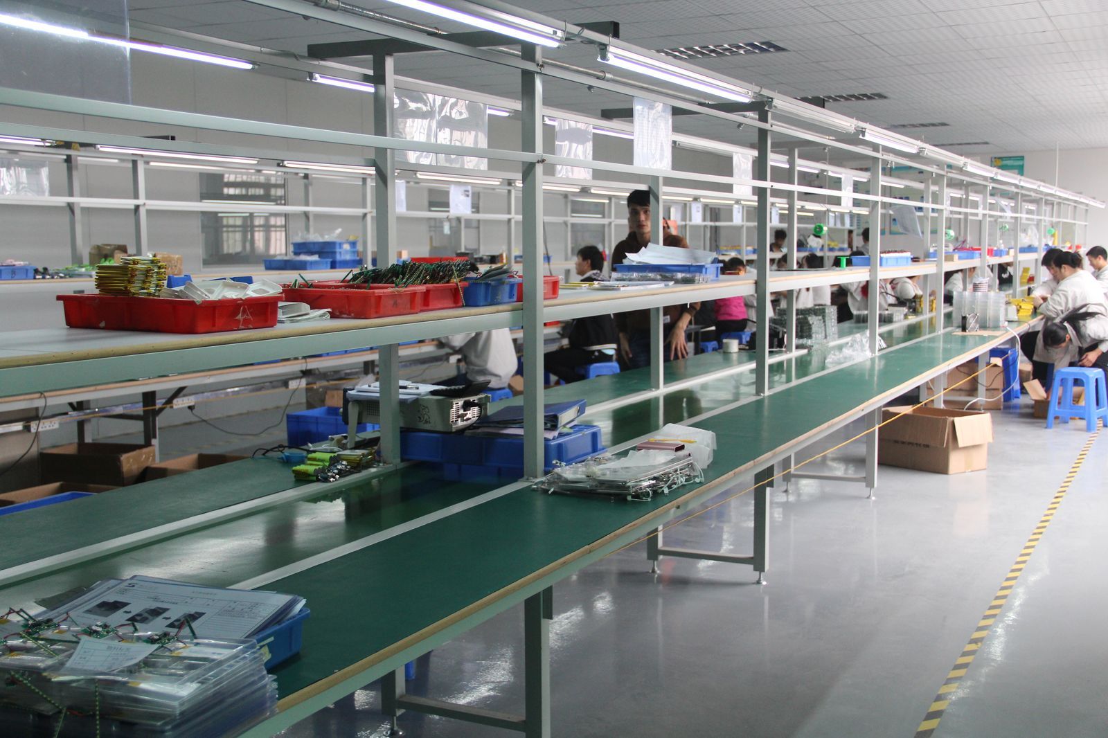 Assembly workshop overview with green conveyor belts at YHR Technology