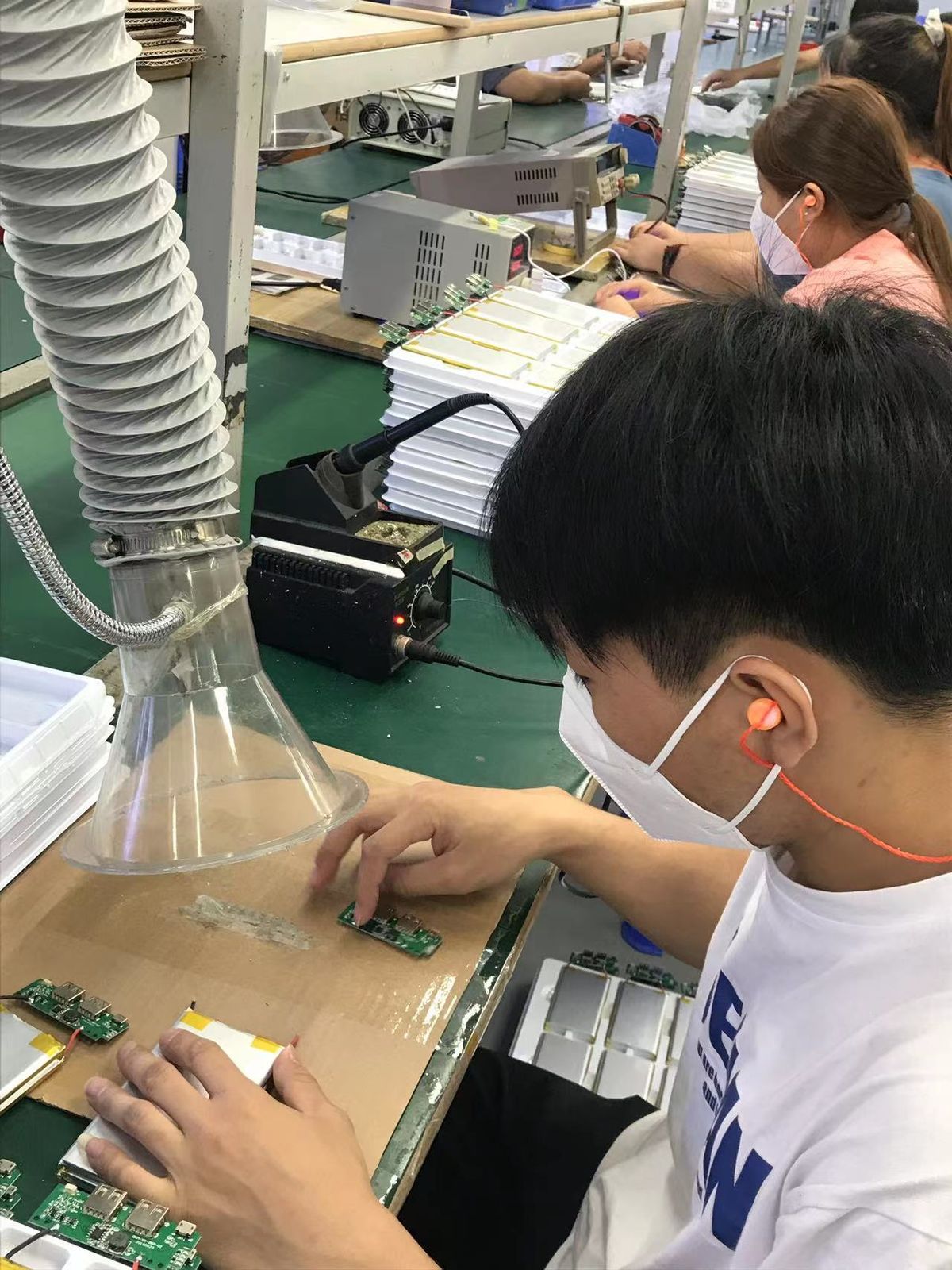 Skilled worker soldering a PCB on the production line at YHR Technology